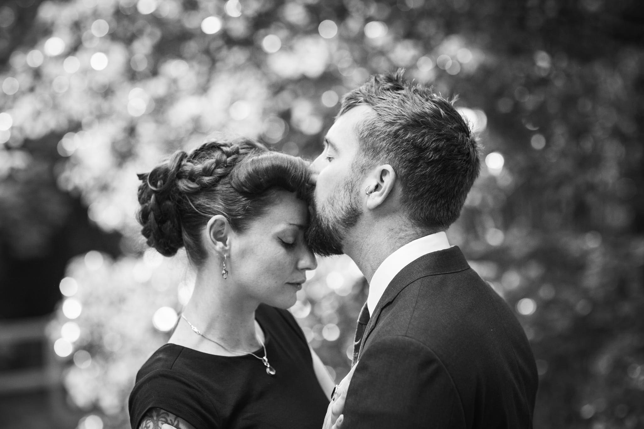 couple in formal dress giving forehead kiss