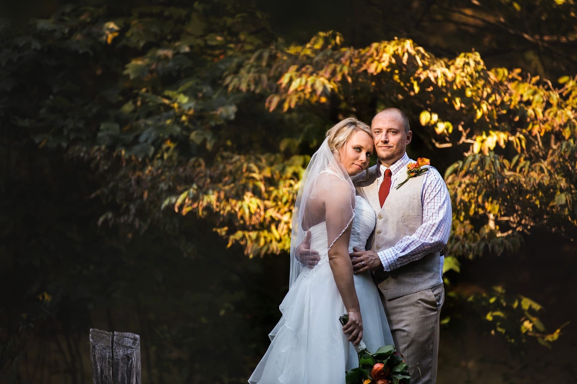 Couple embracing over lake with beautiful light behind them