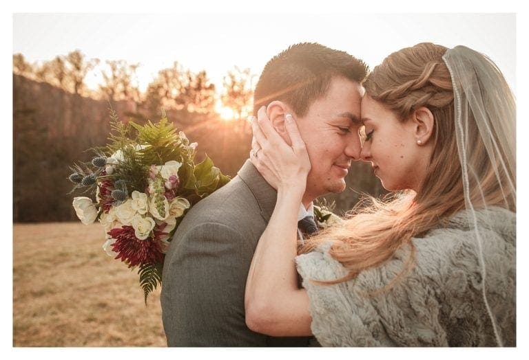 Bride and groom embracing at sunset smiling