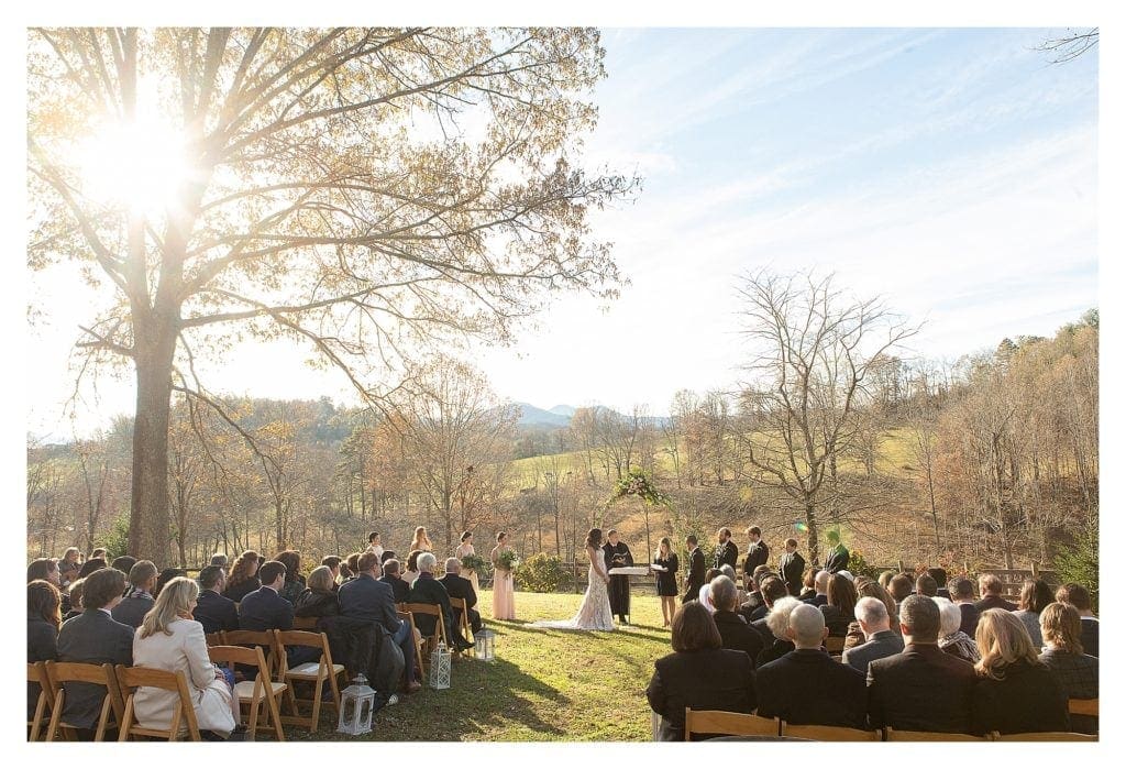 Wedding ceremony outdoors with mountains and green fields in background on sunny day - kathy beaver photography