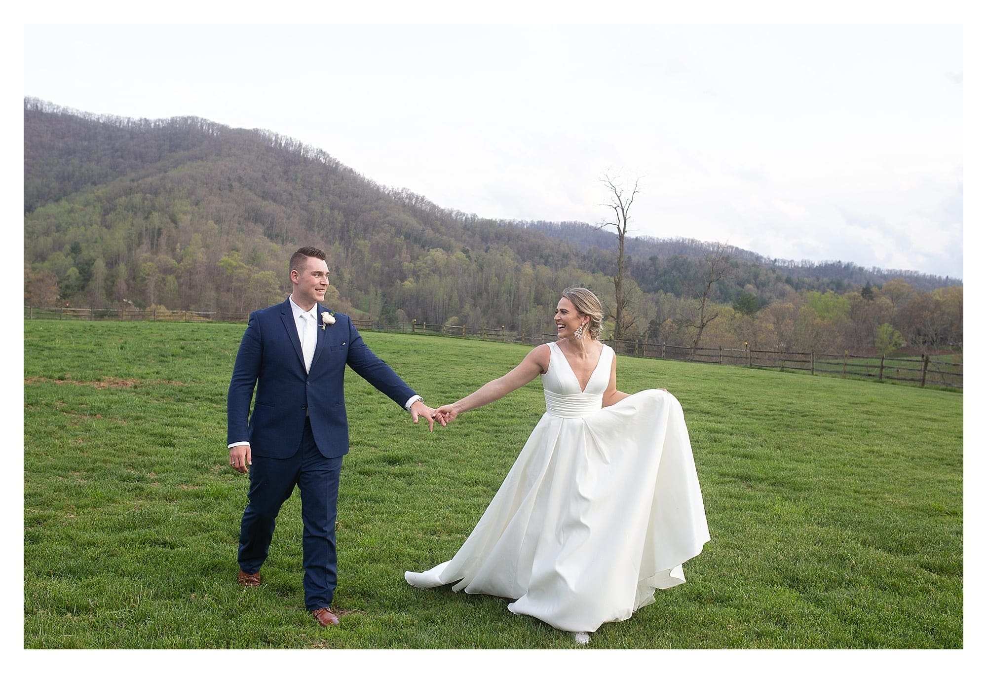 Bride and groom holding hands in grassy field