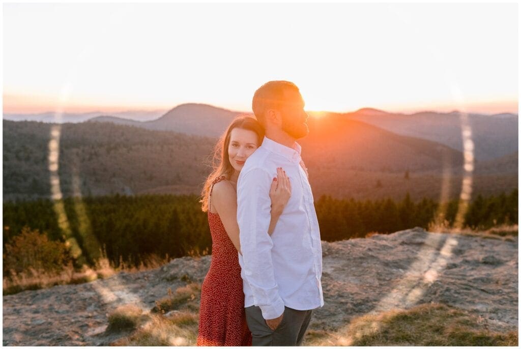 Sunset engagement photo with a sun flare around the couple.