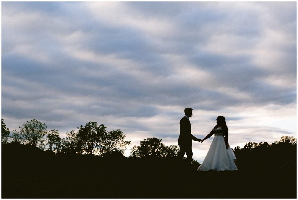 Silhouette portrait of the bride and groom with the clouds.