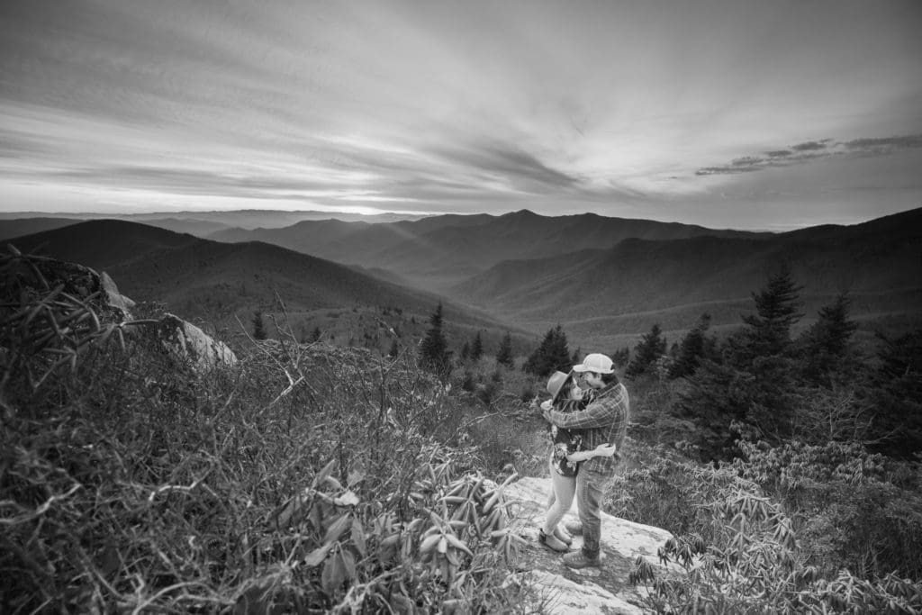 Black and white photo of Bethany and Andy hugging on a mountain | Asheville Engagement Photographer