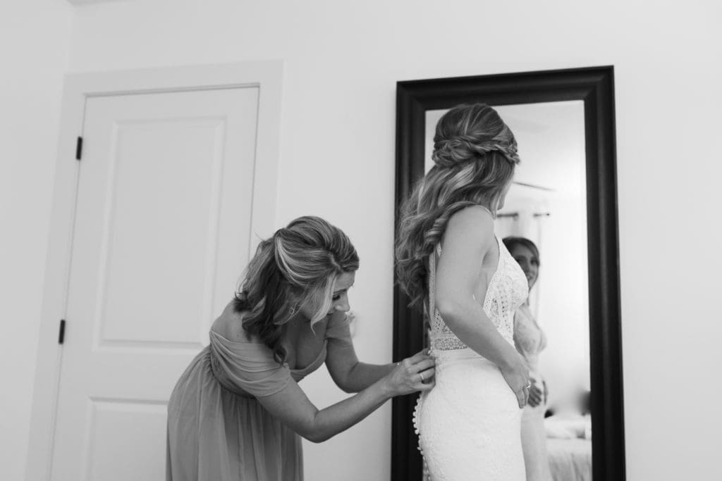The maid of honor helps button the brides wedding dress | Kathy Beaver Photography | Asheville Wedding Photographer