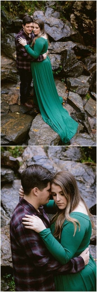 Asheville engagement photos of a girl wearing a long green dress and a man wearing a dark plaid shirt next to a waterfall.