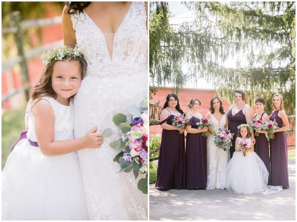 The flower girl leans in to hug the bride, and the bride standing next to all her bridesmaids in deep purple dresses | Asheville Wedding Photographer
