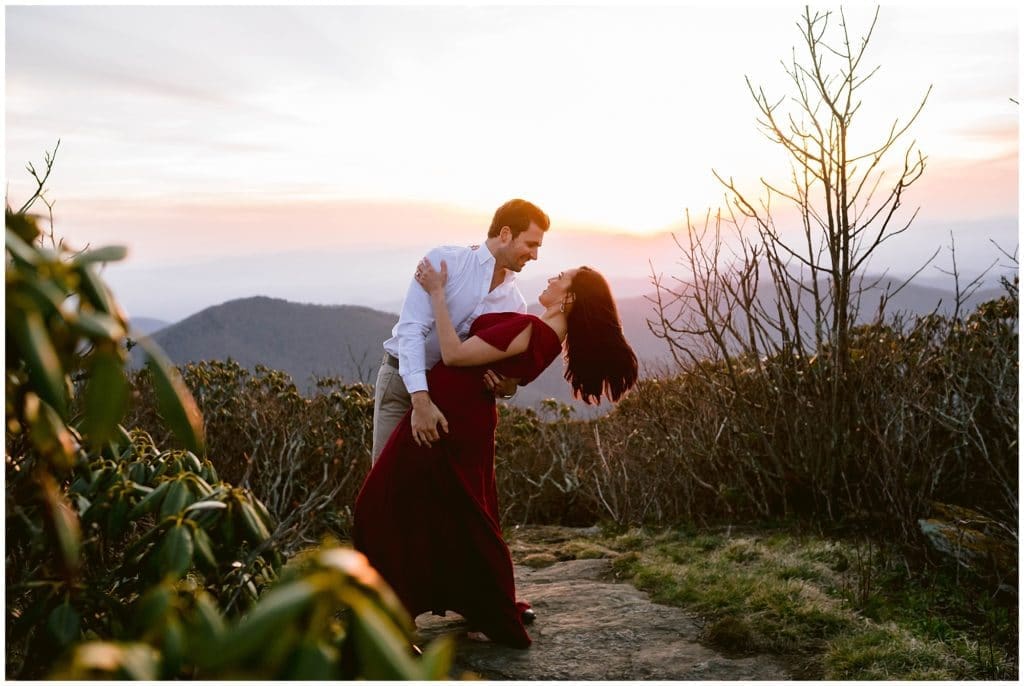 Steve dips Nicole back to kiss her with the sunset behind them | Asheville Engagement Photographer