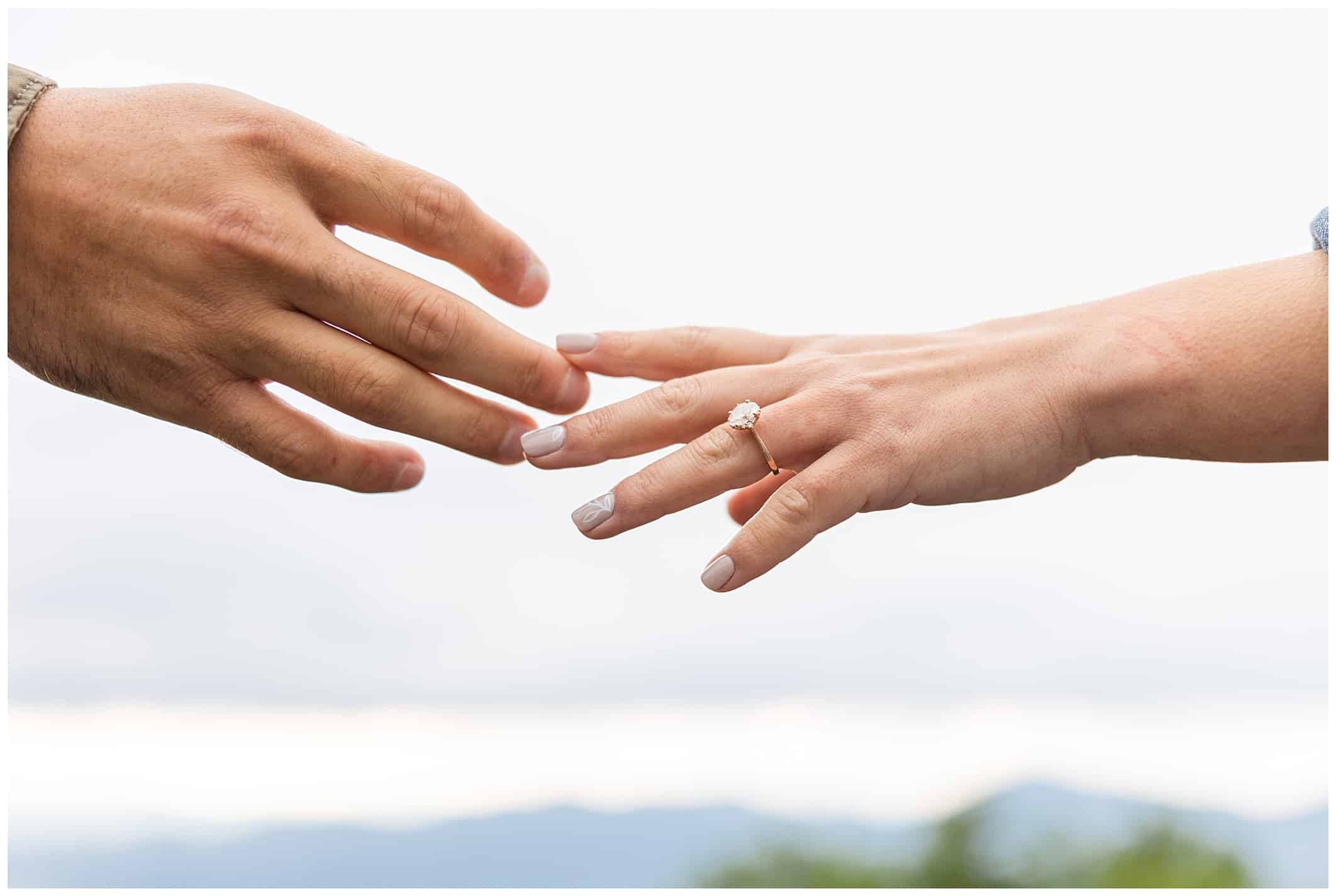 Couple touches hands for their engagement session