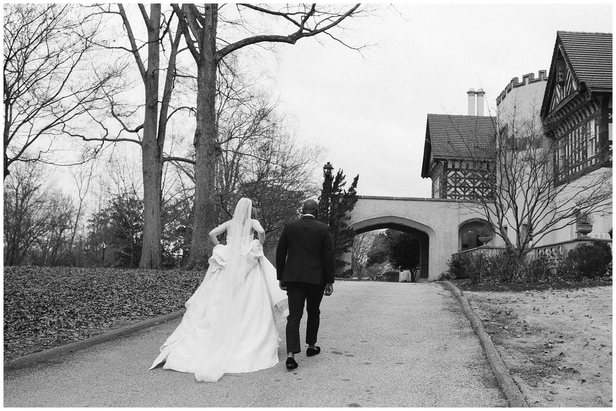 black and white photo of bride and groom walking outside
