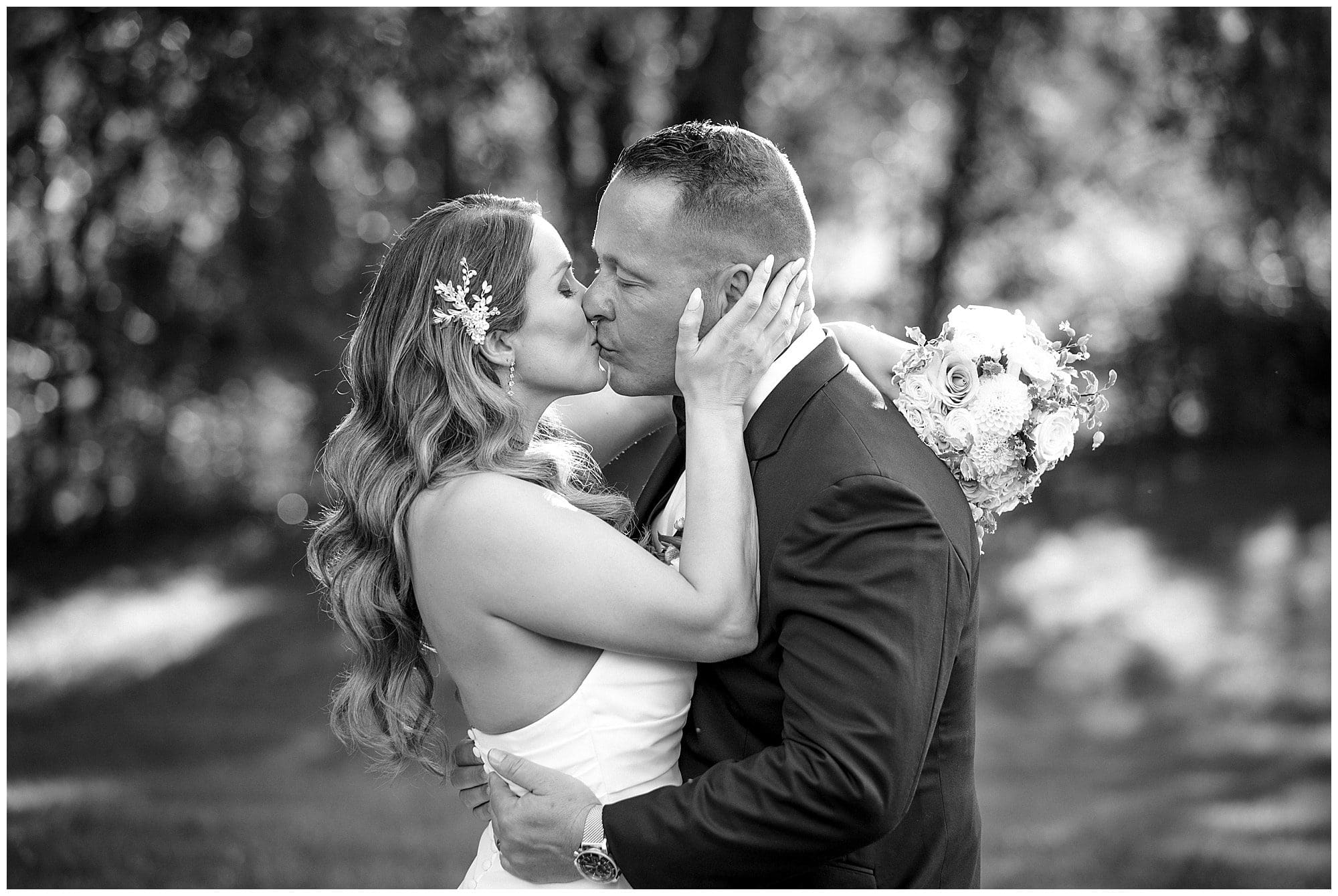 black and white photo of bride and groom  sharing a kiss after getting married