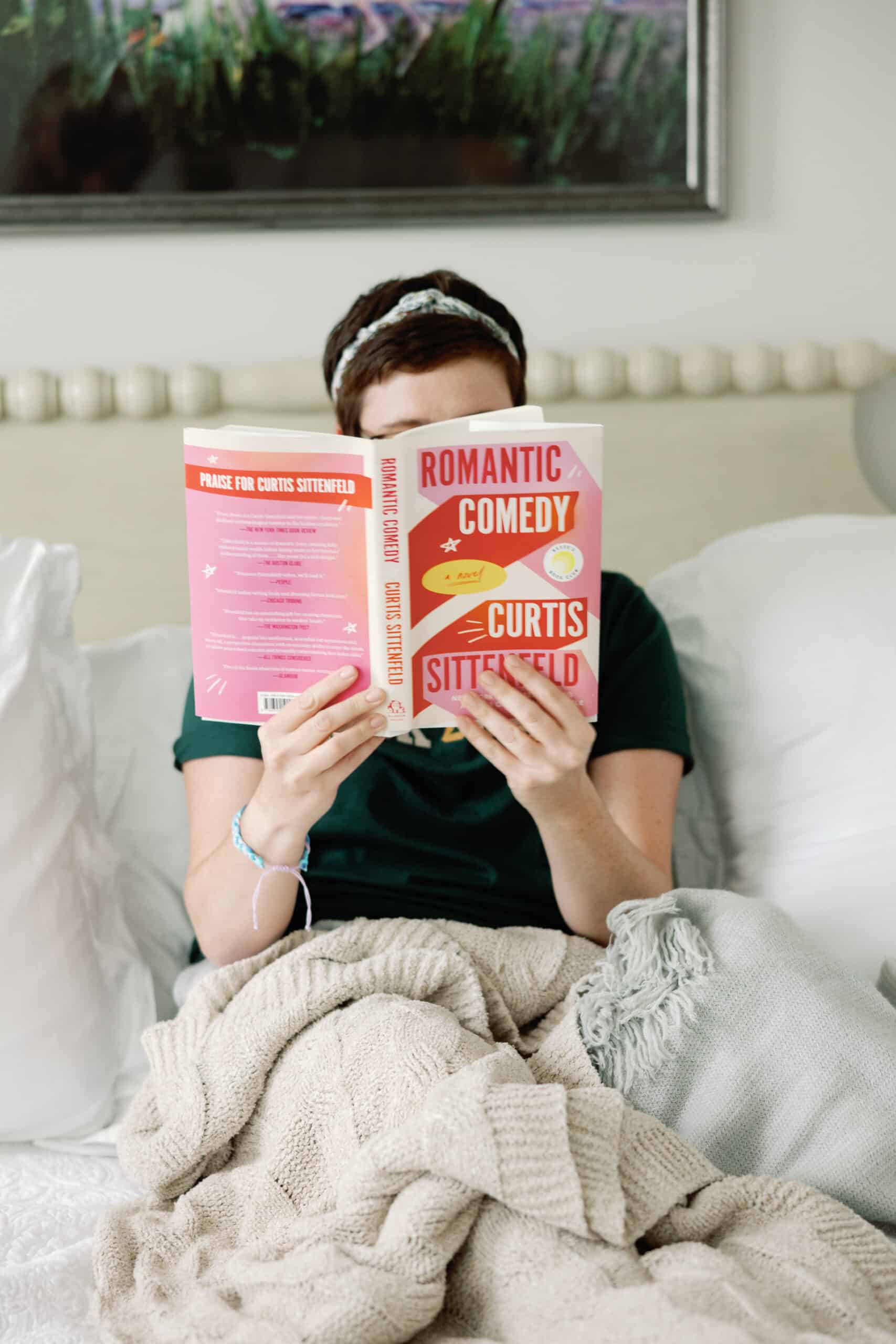 A woman reading a book in bed during the 2024 Winter Content Creation Retreat.