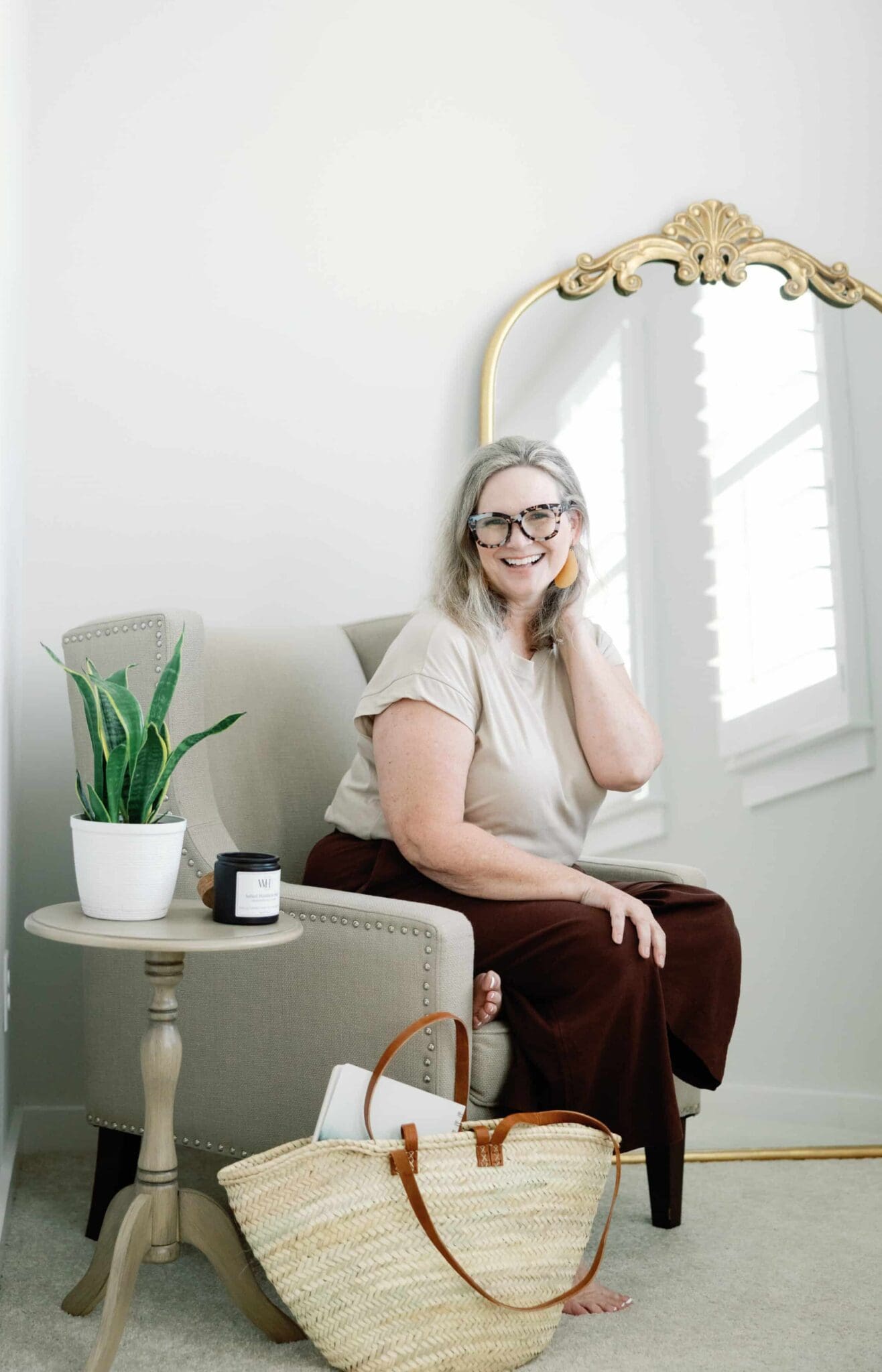 A woman participating in the 2024 Winter Content Creation Retreat poses with a mirror and basket.