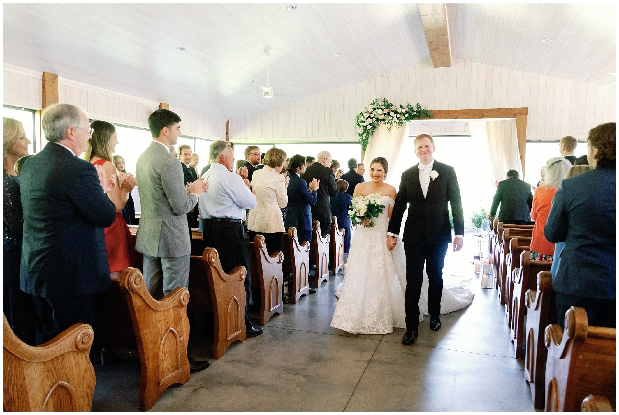 A bride and groom walking down the aisle of a church.