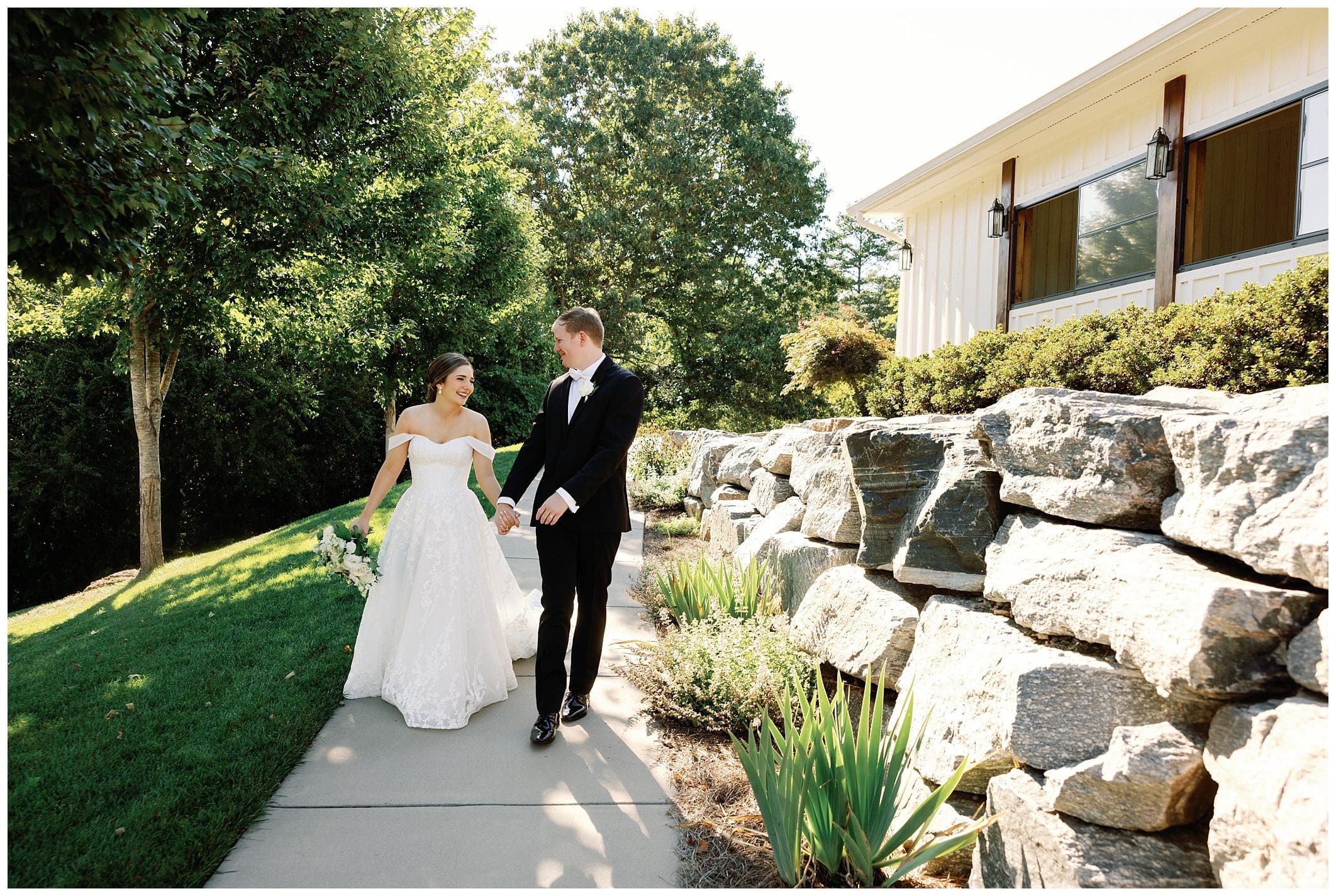 A bride and groom walking down a stone path.