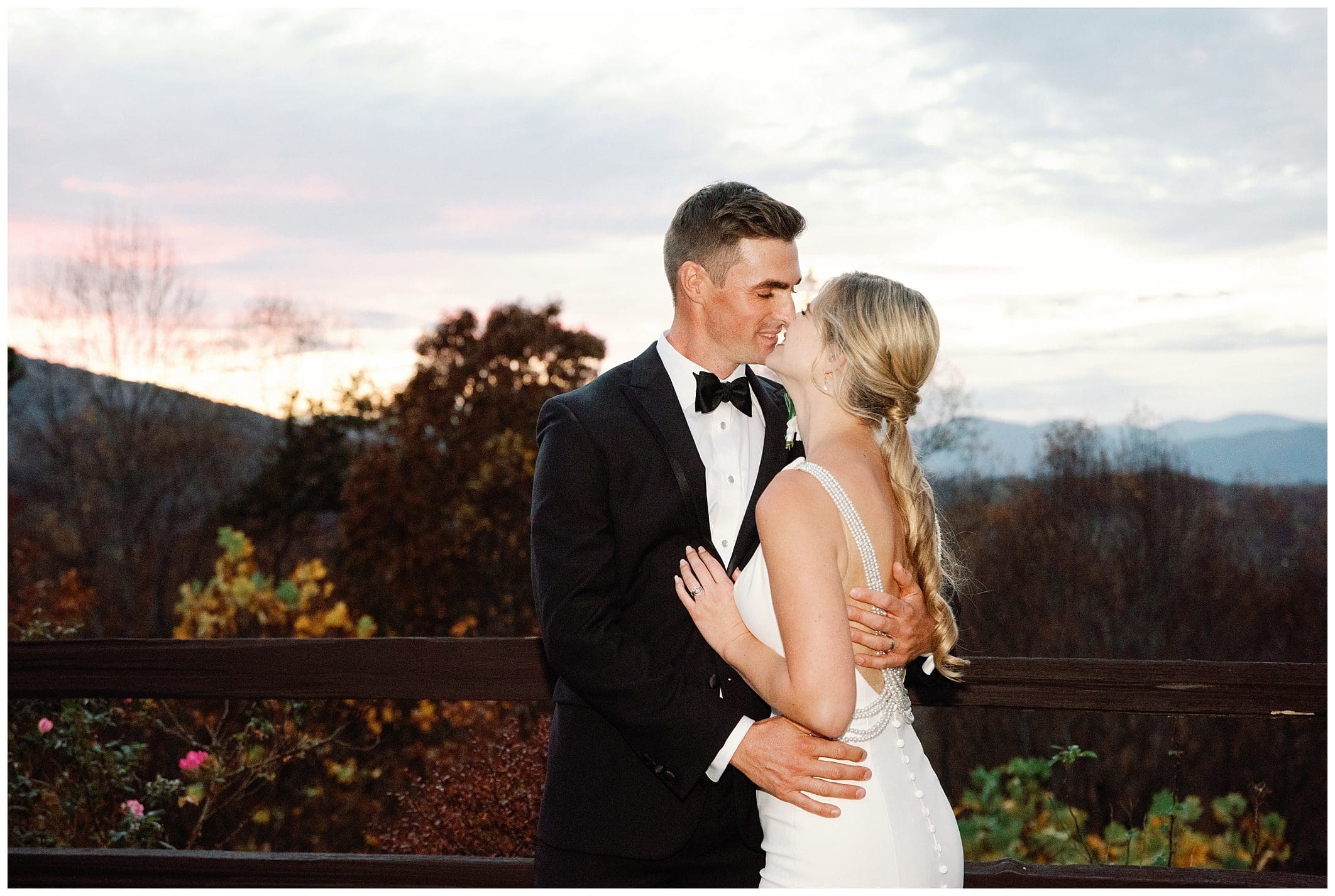 A bride and groom sharing a passionate kiss on a balcony at the Crest Center during their fall wedding.