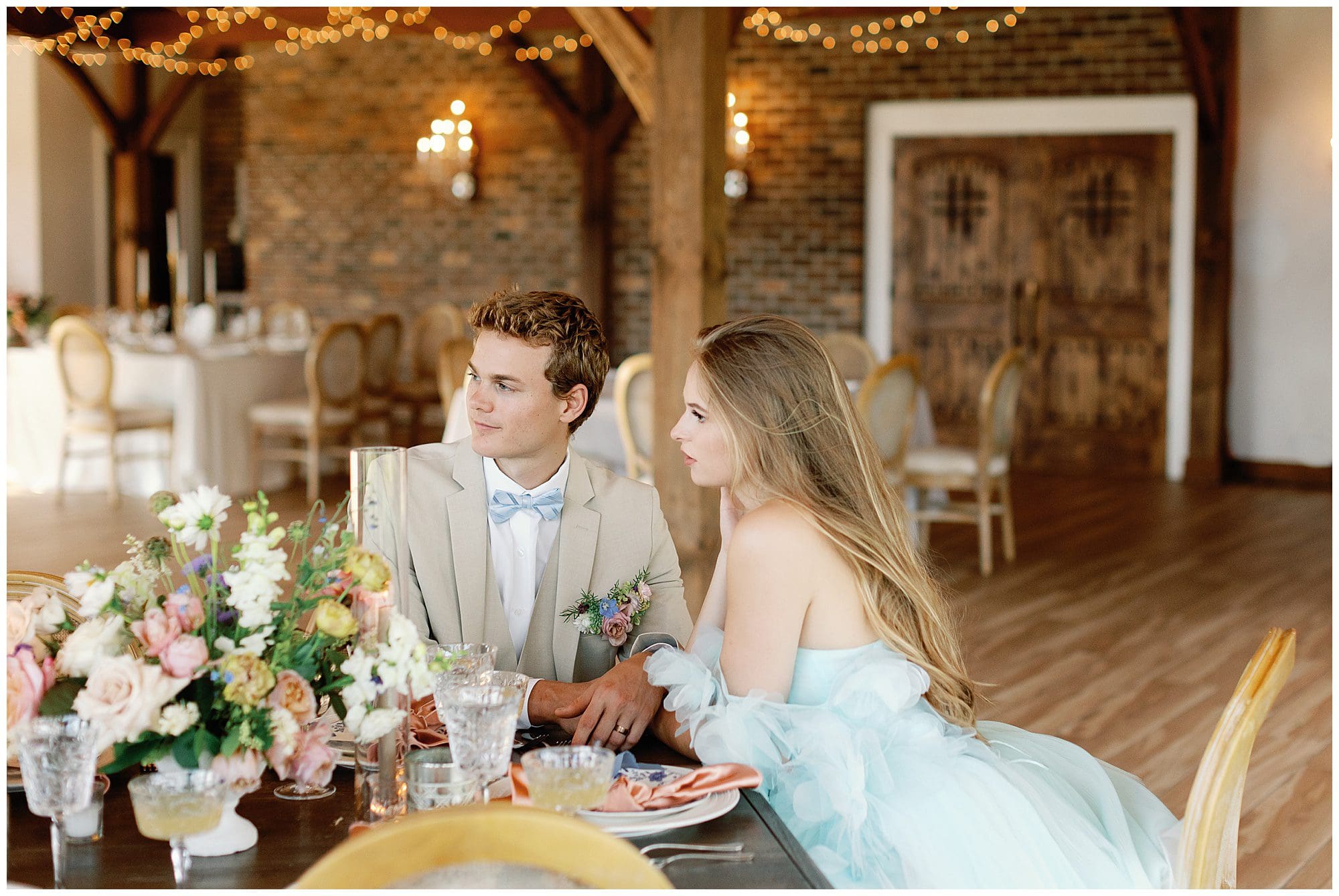 A Parisian-inspired summer wedding at The Ridge, with a bride and groom sitting at a table during the reception.