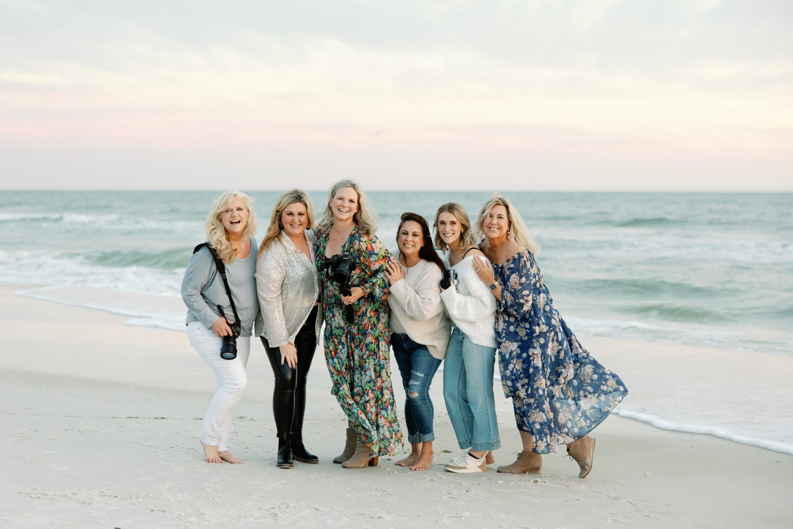 A group of women attending a photography retreat on Rosemary Beach, posing for a photo.