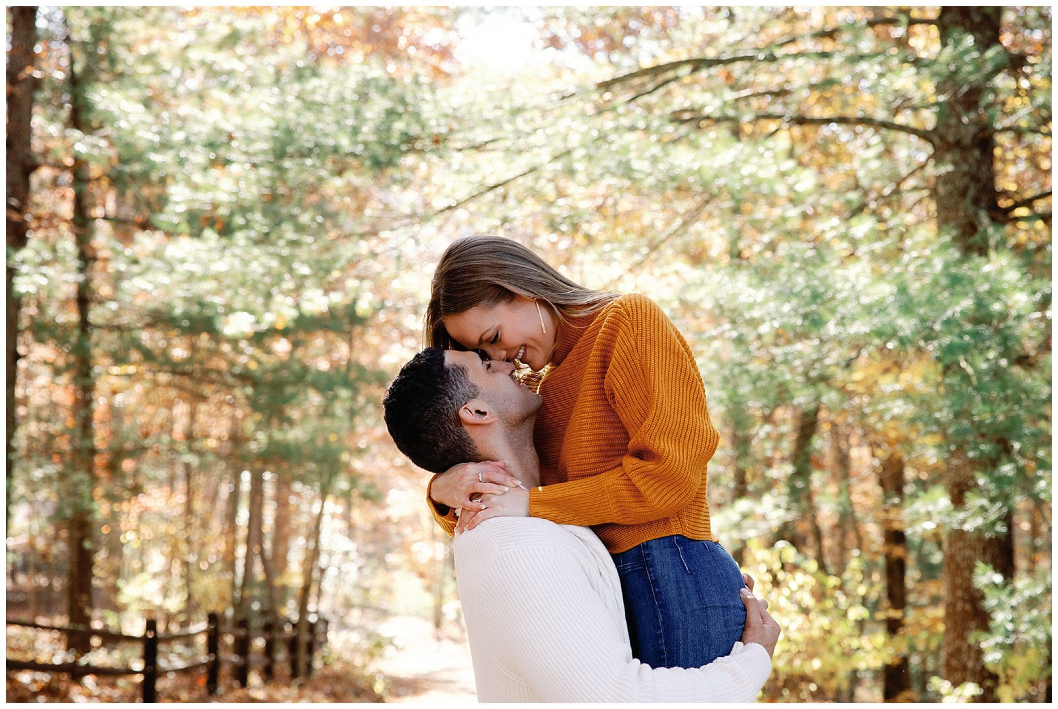 A couple sharing a tender sunrise engagement moment in an autumnal forest setting.