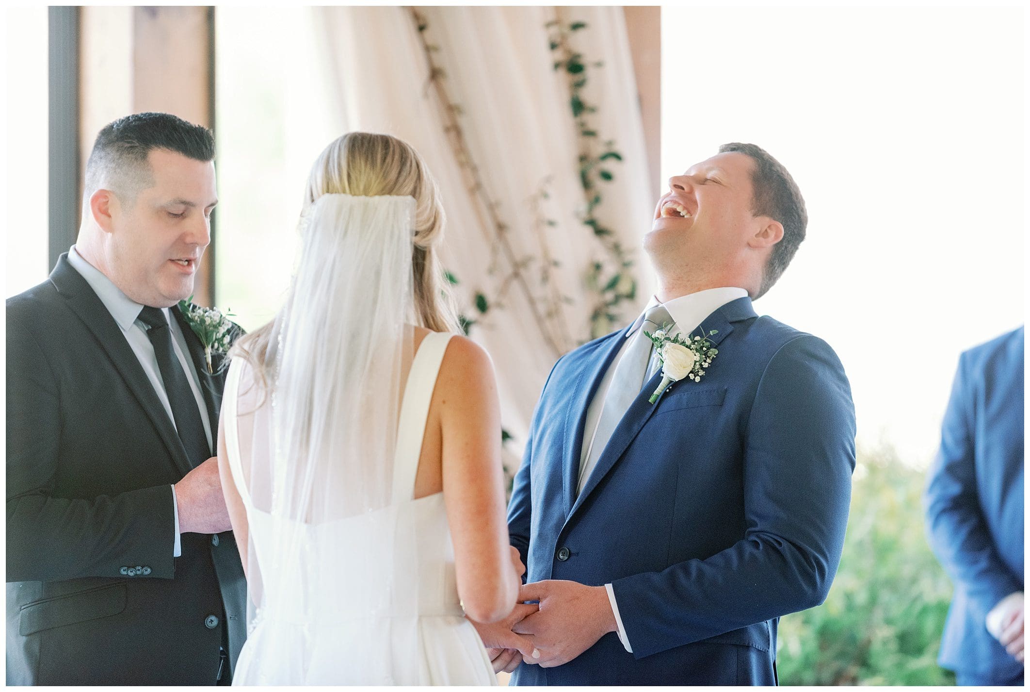 A bride and groom laughing during their wedding ceremony.