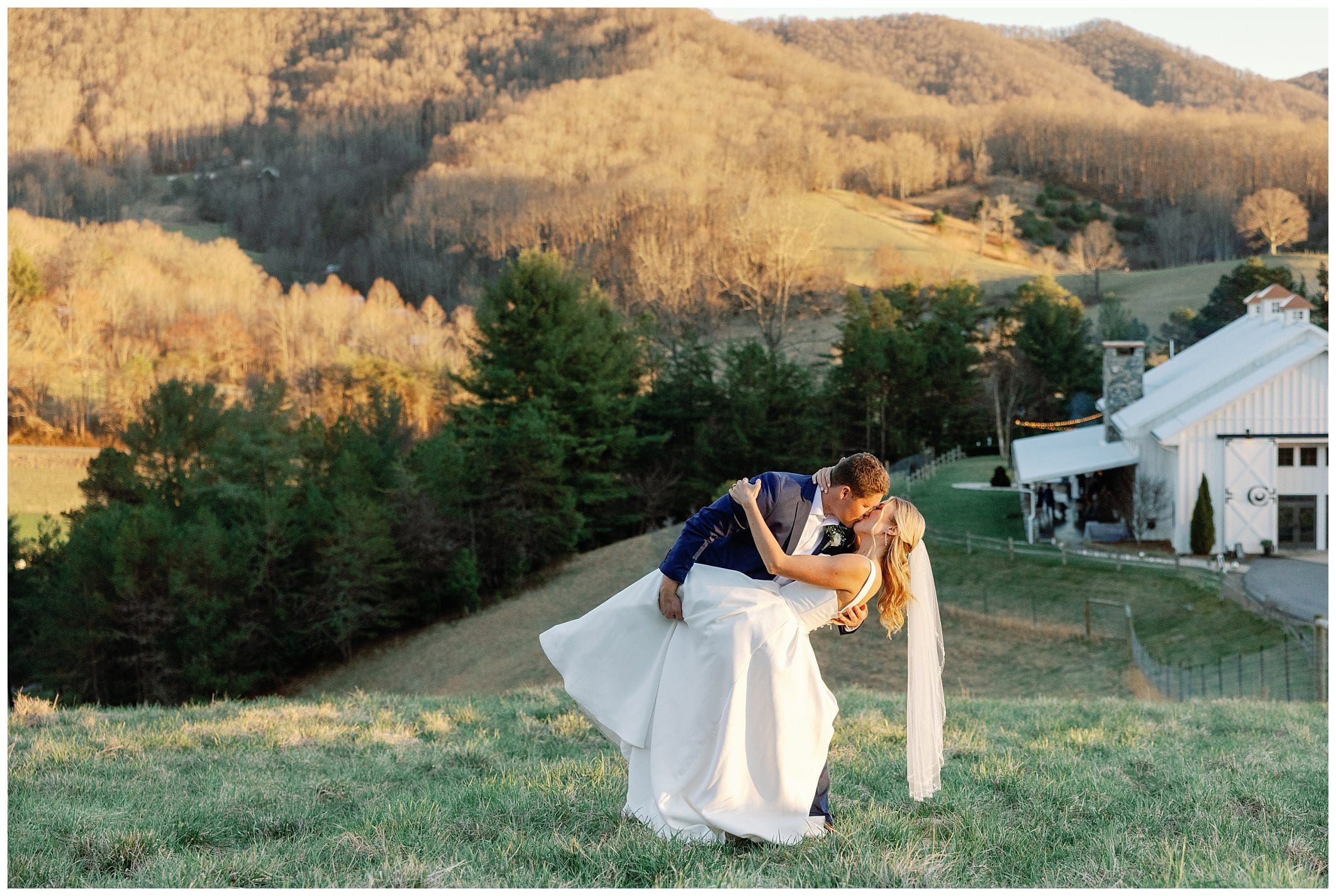 A bride and groom kissing in front of a mountain.