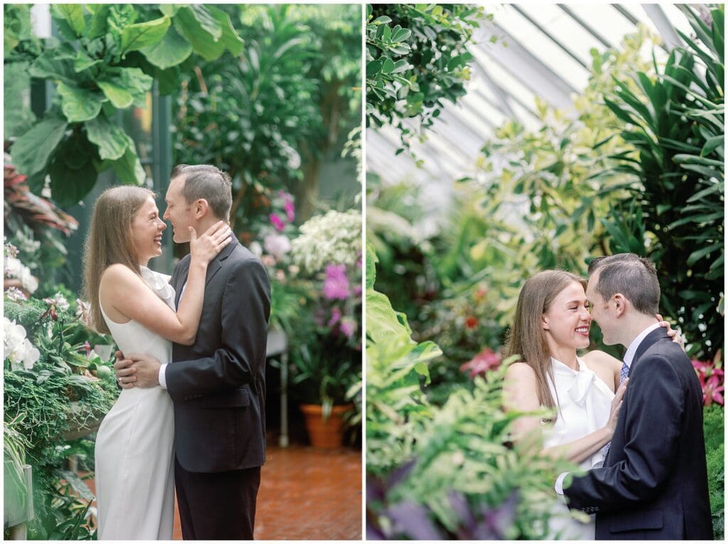 A couple shares an intimate moment during their spring engagement session, kissing and embracing amidst lush, green plants in a brightly lit greenhouse at Biltmore.
