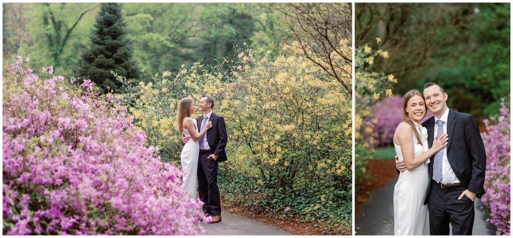 A couple embraces in a lush garden during their spring engagement session at Biltmore, with blooming pink and yellow flowers surrounding them, conveying a joyful and romantic atmosphere.