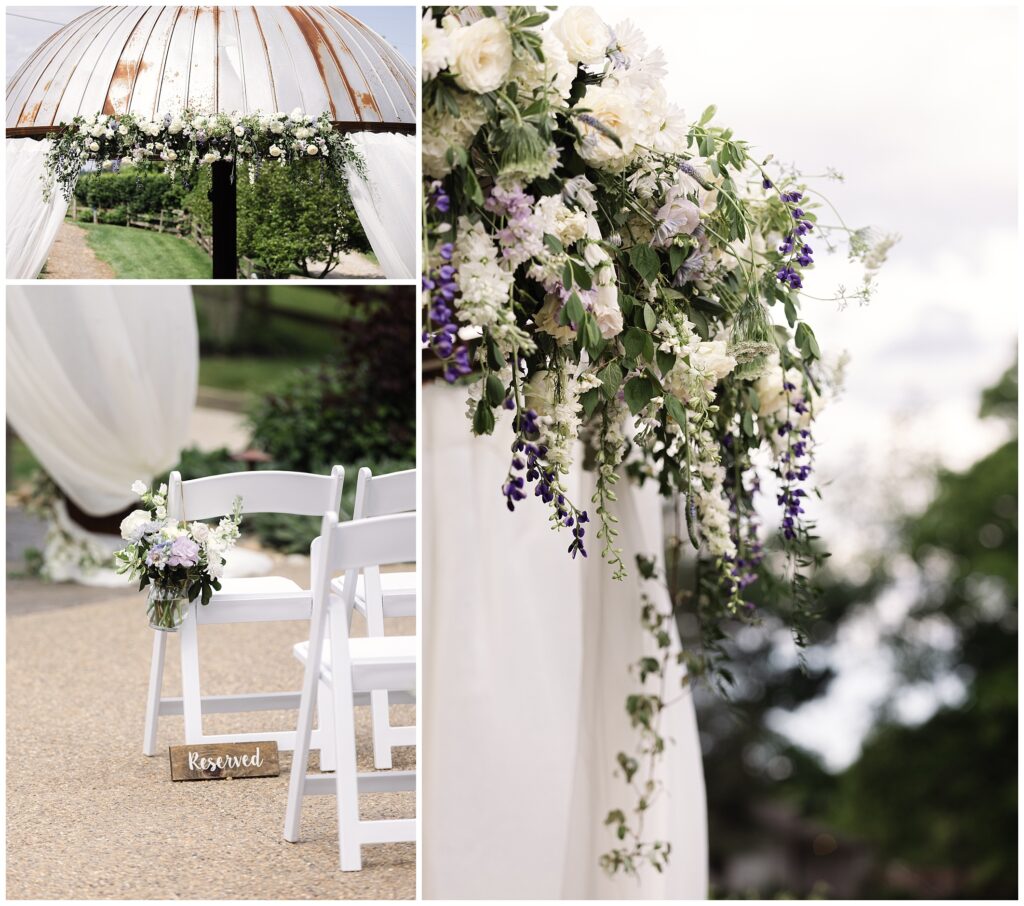 A decorative outdoor wedding setup with floral arrangements, white chairs marked "Reserved," and a floral-covered arch under a cloudy sky.