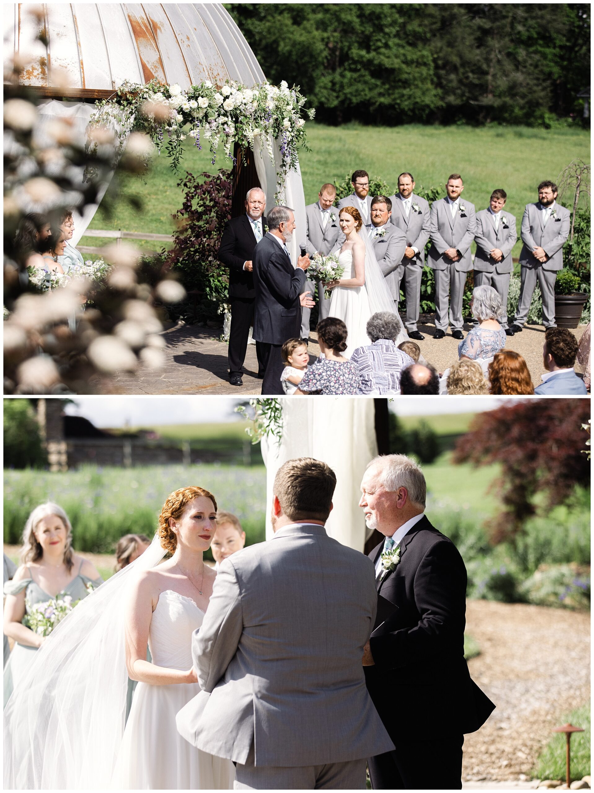 A bride and groom stand at an outdoor wedding ceremony, exchanging vows under a floral arch. Bridesmaids in grey dresses and groomsmen in grey suits are present. Guests are seated, watching the ceremony.