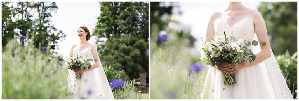 A bride in a white dress holds a bouquet of flowers, standing in a field with greenery and blue flowers.