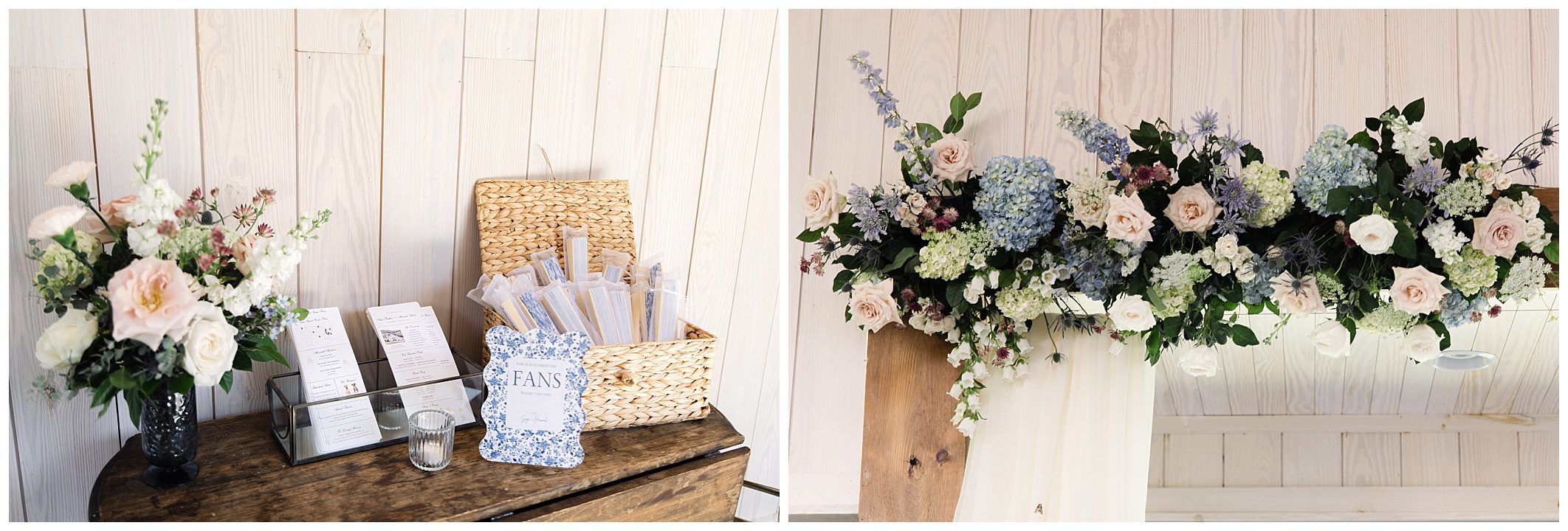 A display table features a bouquet, wedding program fans in a wicker basket, and other items. Above, a floral arrangement with blue, white, and pink flowers decorates a wooden backdrop.