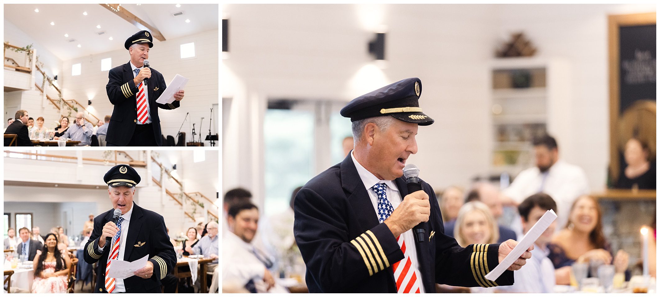 A man dressed as an airline pilot reads from a sheet of paper and speaks into a microphone during an indoor gathering, with attendees seated and watching in the background.