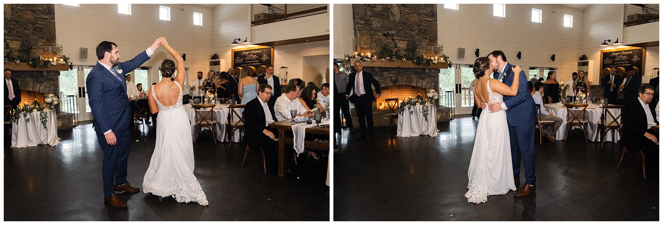 A couple in wedding attire dances in a room with seated guests. The groom wears a blue suit; the bride, a white dress. The background features large windows, a stone fireplace, and decorative lighting.