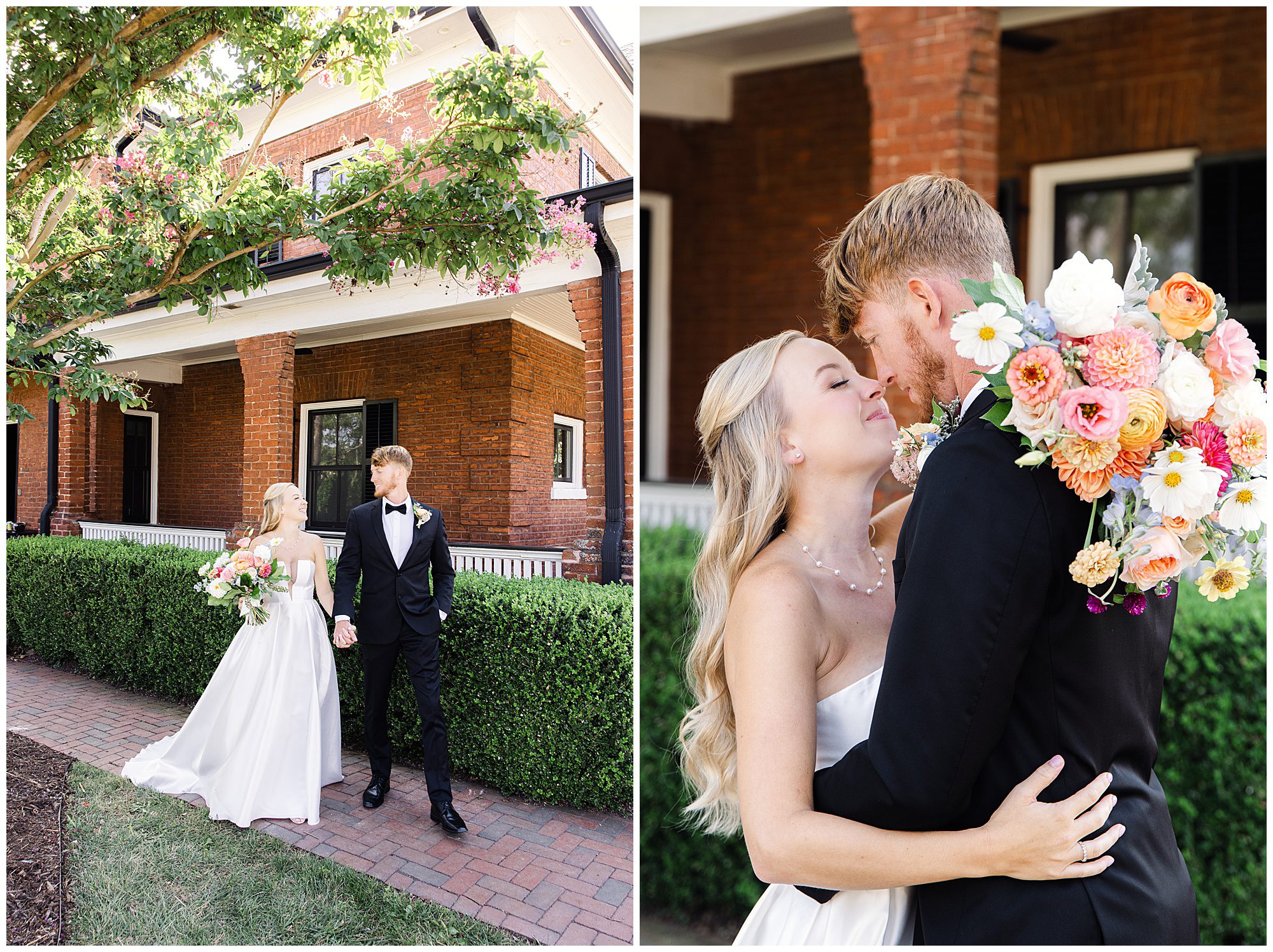 A bride and groom stand hand-in-hand outside a brick building and share a kiss. The bride holds a colorful bouquet of flowers.