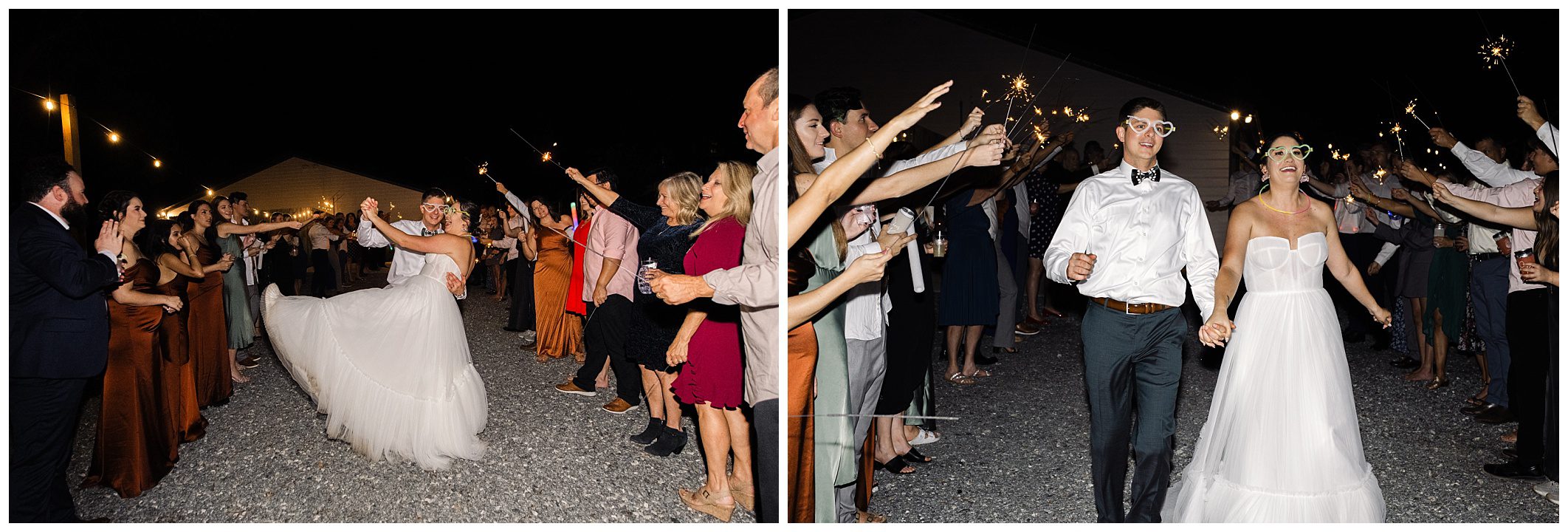 A couple in wedding attire walks through a crowd holding sparklers at night.