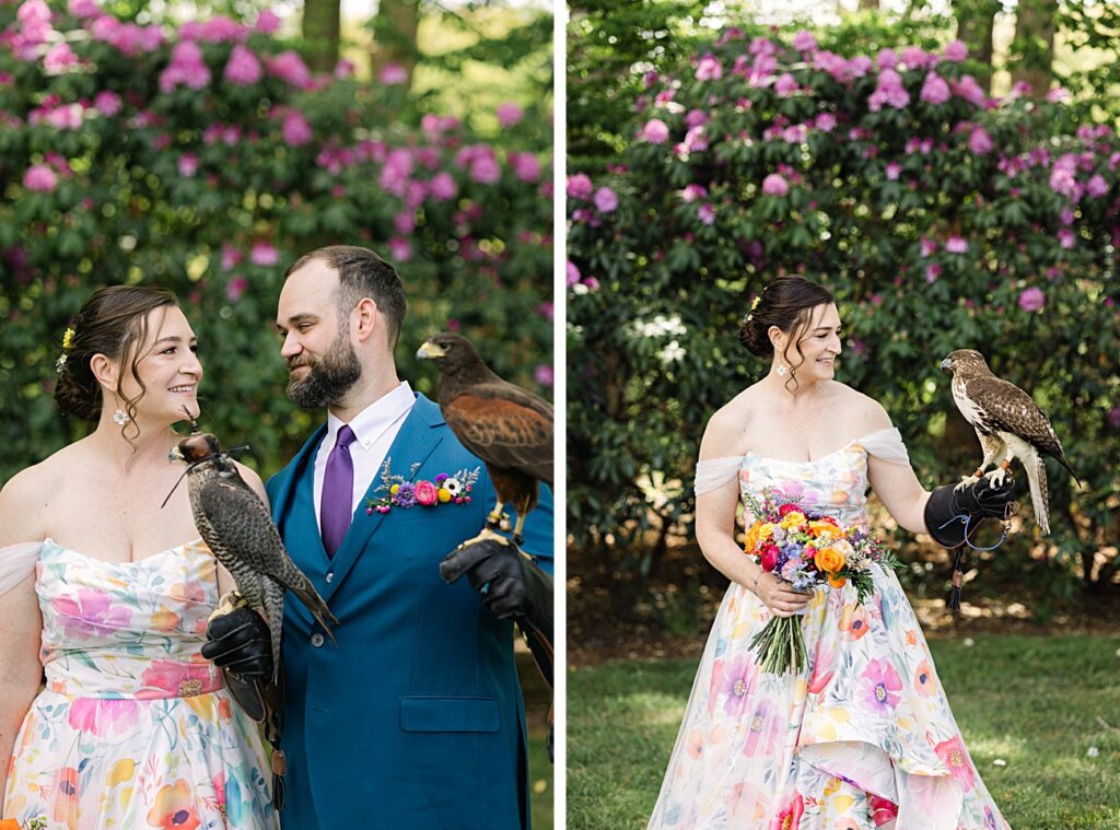 A couple in formal attire stands outdoors with falcons perched on their gloved hands; purple flowers and greenery evoke the charm of a Spring Garden Wedding in Asheville, NC.