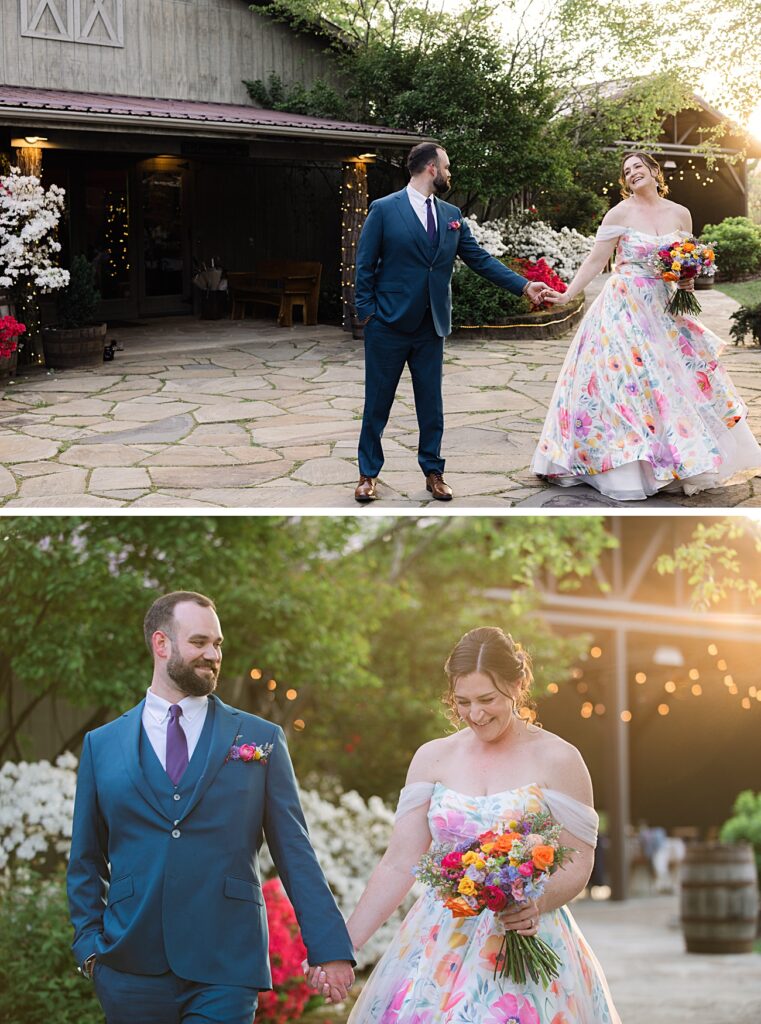 A couple in formal wedding attire holds hands and smiles outside a rustic building, surrounded by greenery and flowers. Perfect for a Spring Garden Wedding in Asheville NC, the bride wears a floral dress and holds a colorful bouquet.