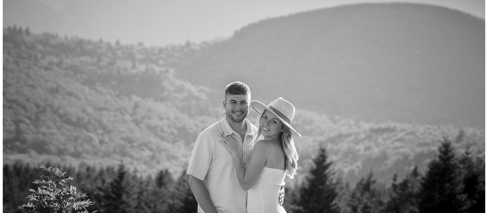 A black and white photo of an engaged couple in the mountains.