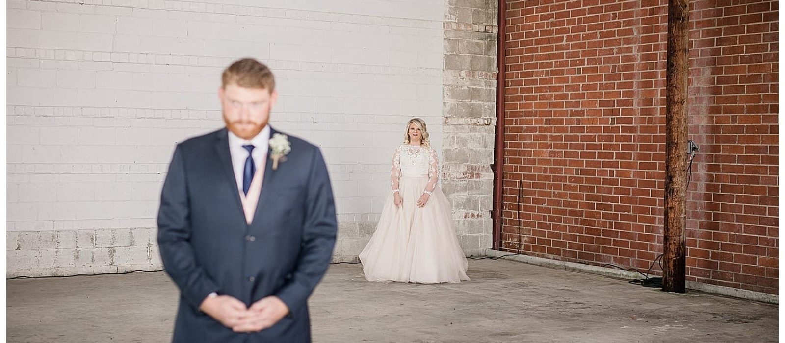 Photo of bride standing a few feet behind groom awaiting their first look of one another on their wedding day