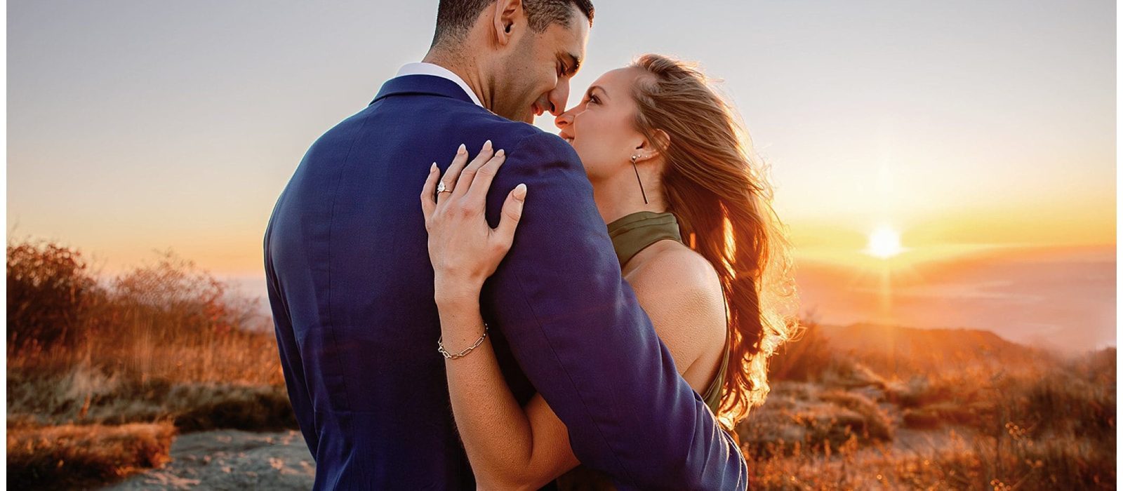 Couple embracing at sunrise with scenic black balsam view.